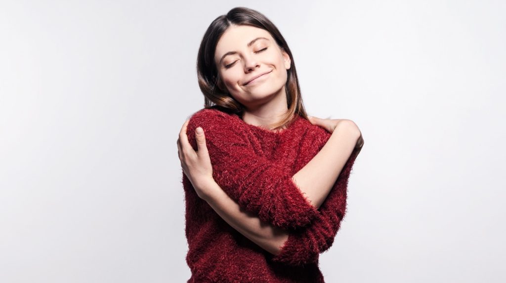 Mulher se abraçando.